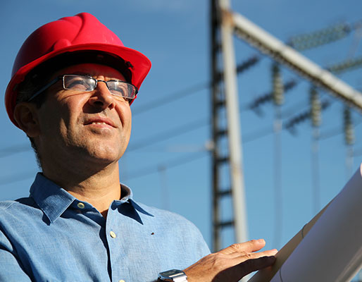 un ingénieur regarde au loin sur un site industriel